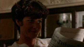 Movie still from “The Sheltering Sky” (1990), directed by Bernardo Bertolucci – A woman is smiling while reading a newspaper; Close Up shot, Over the shoulder angle