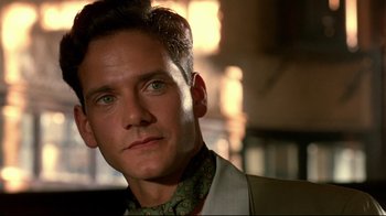 Movie still from “The Sheltering Sky” (1990), directed by Bernardo Bertolucci – A person wearing a suit and tie; Close Up shot, Low angle