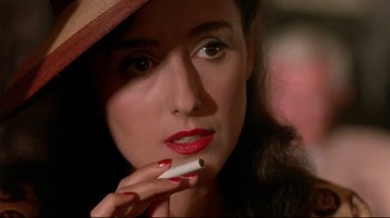 A woman with red lipstick is smoking a cigarette