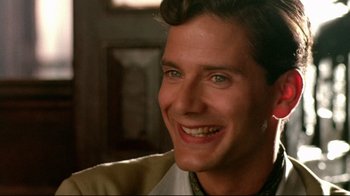 Movie still from “The Sheltering Sky” (1990), directed by Bernardo Bertolucci – A person with a smile on their face; Close Up shot, Low angle