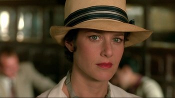 Movie still from “The Sheltering Sky” (1990), directed by Bernardo Bertolucci – A person wearing a hat; Close Up shot, Over the shoulder angle