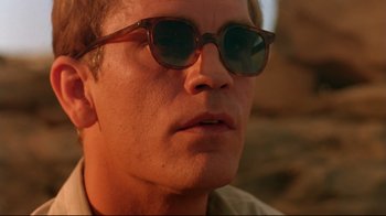 Movie still from “The Sheltering Sky” (1990), directed by Bernardo Bertolucci – A person wearing sunglasses; Close Up shot, Low angle