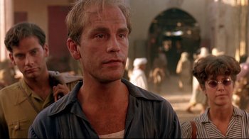 Movie still from “The Sheltering Sky” (1990), directed by Bernardo Bertolucci – A person wearing a blue shirt; Close Up shot, Low angle