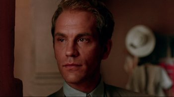 Movie still from “The Sheltering Sky” (1990), directed by Bernardo Bertolucci – A man that is wearing a suit and a tie; Close Up shot, Low angle