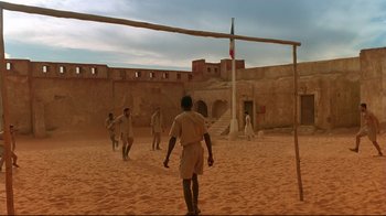 Movie still from “The Sheltering Sky” (1990), directed by Bernardo Bertolucci – A group of men playing a game of volley ball; Wide shot, Low angle