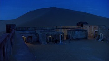 Movie still from “The Sheltering Sky” (1990), directed by Bernardo Bertolucci – An image of an outdoor setting at night time; Extreme Wide shot, High angle