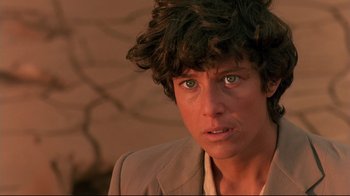 Movie still from “The Sheltering Sky” (1990), directed by Bernardo Bertolucci – A person wearing a jacket; Close Up shot, Over the shoulder angle