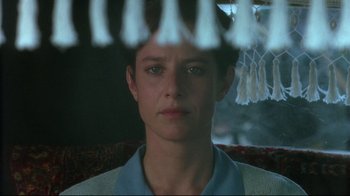 Movie still from “The Sheltering Sky” (1990), directed by Bernardo Bertolucci – A man looking at the camera through a window; Close Up shot, Low angle