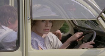 Movie still from “The Shout” (1978), directed by Jerzy Skolimowski – A woman sitting in the driver's seat of a car; Close Up shot, High angle