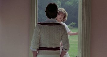 Movie still from “The Shout” (1978), directed by Jerzy Skolimowski – Two women standing next to each other in front of an open window; Medium shot, Over the shoulder angle