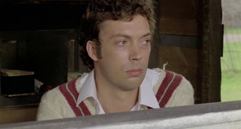 Movie still from “The Shout” (1978), directed by Jerzy Skolimowski – A person wearing a shirt and a sweater; Close Up shot, Low angle