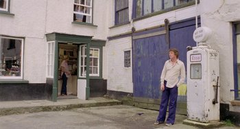 Movie still from “The Shout” (1978), directed by Jerzy Skolimowski – A man standing in front of a door way; Wide shot, Low angle