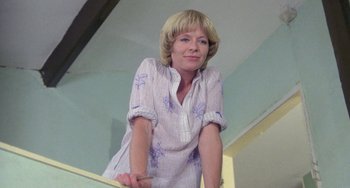 Movie still from “The Shout” (1978), directed by Jerzy Skolimowski – A woman standing on top of a stair railing; Medium shot, Low angle