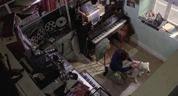 Movie still from “The Shout” (1978), directed by Jerzy Skolimowski – A man kneeling down in front of a keyboard; Wide shot, Overhead angle