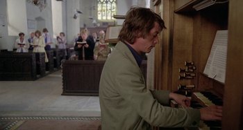 Movie still from “The Shout” (1978), directed by Jerzy Skolimowski – A man in a suit playing a piano in a church; Medium shot, Low angle