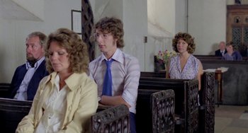 Movie still from “The Shout” (1978), directed by Jerzy Skolimowski – A man and a woman sitting in a church; Medium shot, Over the shoulder angle
