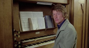 Movie still from “The Shout” (1978), directed by Jerzy Skolimowski – A man standing in front of an organ; Close Up shot, Low angle