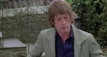 Movie still from “The Shout” (1978), directed by Jerzy Skolimowski – A person wearing a jacket; Close Up shot, Over the shoulder angle