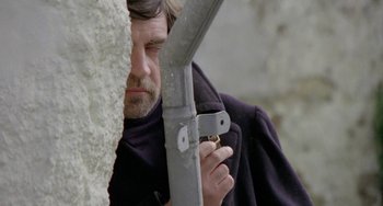 Movie still from “The Shout” (1978), directed by Jerzy Skolimowski – A man holding a large knife in front of his face; Close Up shot, Low angle
