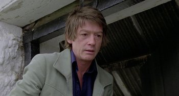 Movie still from “The Shout” (1978), directed by Jerzy Skolimowski – A person wearing a jacket; Close Up shot, Low angle