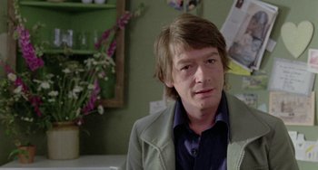 Movie still from “The Shout” (1978), directed by Jerzy Skolimowski – A man in a green jacket sitting in front of a mirror; Close Up shot, Over the shoulder angle