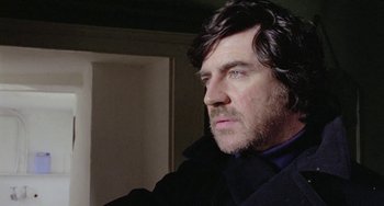 Movie still from “The Shout” (1978), directed by Jerzy Skolimowski – A person wearing a black jacket; Close Up shot, Low angle