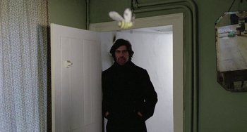 Movie still from “The Shout” (1978), directed by Jerzy Skolimowski – A man standing in front of an open door; Medium shot, Low angle