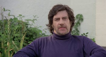 Movie still from “The Shout” (1978), directed by Jerzy Skolimowski – A person wearing a purple shirt; Close Up shot, Low angle