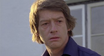 Movie still from “The Shout” (1978), directed by Jerzy Skolimowski – A person wearing a blue shirt; Close Up shot, Low angle