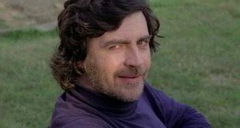 Movie still from “The Shout” (1978), directed by Jerzy Skolimowski – A person wearing a purple shirt; Close Up shot, Low angle