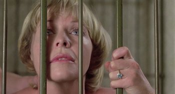 Movie still from “The Shout” (1978), directed by Jerzy Skolimowski – A person behind a fence; Close Up shot, Low angle