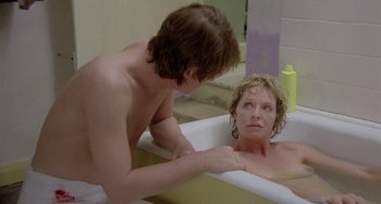 Movie still from “The Shout” (1978), directed by Jerzy Skolimowski – A man and a woman in a bath tub in a bathroom; Medium shot, High angle
