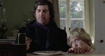 Movie still from “The Shout” (1978), directed by Jerzy Skolimowski – A man and a boy sitting at a dinner table; Close Up shot, Over the shoulder angle