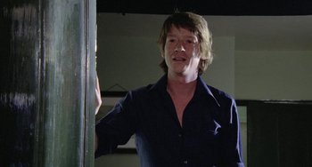 Movie still from “The Shout” (1978), directed by Jerzy Skolimowski – A man standing in front of a window; Close Up shot, Low angle