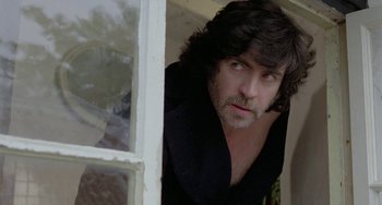 Movie still from “The Shout” (1978), directed by Jerzy Skolimowski – A person looking out of a window; Close Up shot, Low angle