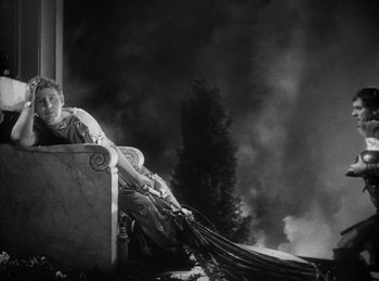 Movie still from “The Sign of the Cross” (1932), directed by Cecil B. DeMille – A man sitting on top of a pillar with smoke in the background; Wide shot, High angle