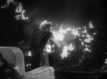 Movie still from “The Sign of the Cross” (1932), directed by Cecil B. DeMille – A man standing in front of a burning building at night; Wide shot, Low angle