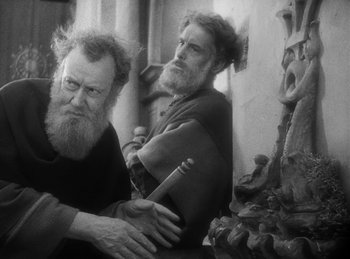 Movie still from “The Sign of the Cross” (1932), directed by Cecil B. DeMille – Two men with long hair and beard sitting next to each other; Medium shot, Low angle
