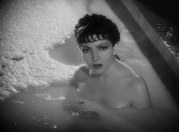 A black - and - white photo of a woman in a tub