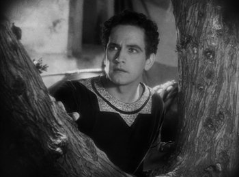 Movie still from “The Sign of the Cross” (1932), directed by Cecil B. DeMille – A black and white photo of a man standing next to a tree; Medium shot, Low angle