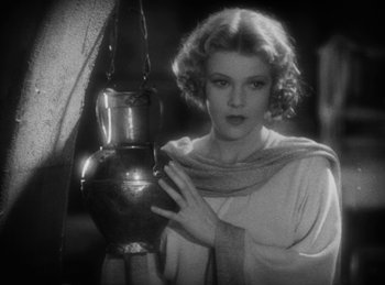 Movie still from “The Sign of the Cross” (1932), directed by Cecil B. DeMille – An old photo of a woman looking at a lamp; Medium shot, Low angle