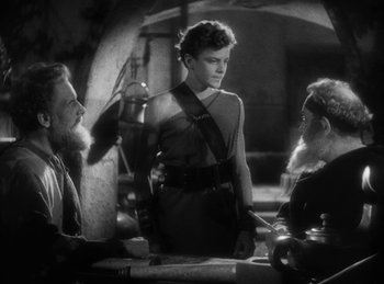 Movie still from “The Sign of the Cross” (1932), directed by Cecil B. DeMille – A black - and - white photo of a man and two women; Medium shot, Over the shoulder angle