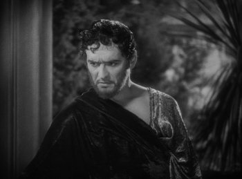 Movie still from “The Sign of the Cross” (1932), directed by Cecil B. DeMille – A man with a beard wearing a black and white image; Close Up shot, Over the shoulder angle