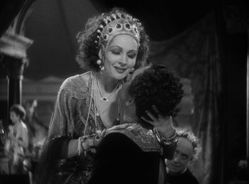 Movie still from “The Sign of the Cross” (1932), directed by Cecil B. DeMille – A woman is hugging a man in front of a crowd; Medium shot, Over the shoulder angle
