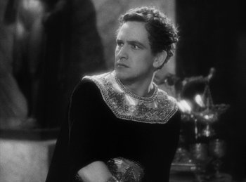 Movie still from “The Sign of the Cross” (1932), directed by Cecil B. DeMille – A man in a black and white photo looking at the camera; Close Up shot, Low angle