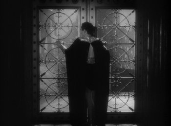 Movie still from “The Sign of the Cross” (1932), directed by Cecil B. DeMille – A woman standing in front of an ornate glass door; Medium shot, Low angle