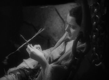 Movie still from “The Sign of the Cross” (1932), directed by Cecil B. DeMille – A woman sitting in a chair and holding a stick; Close Up shot, High angle