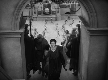 Movie still from “The Sign of the Cross” (1932), directed by Cecil B. DeMille – A black and white photo of people walking through an archway; Extreme Wide shot, High angle