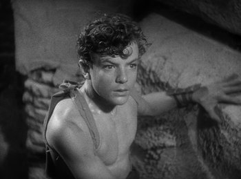 Movie still from “The Sign of the Cross” (1932), directed by Cecil B. DeMille – A young man is posing for a picture in a rocky area; Close Up shot, High angle