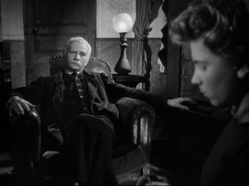 Movie still from “The Silence of the Sea” (1949), directed by Jean-Pierre Melville – An older man sitting in a chair with a young woman; Medium shot, Over the shoulder angle